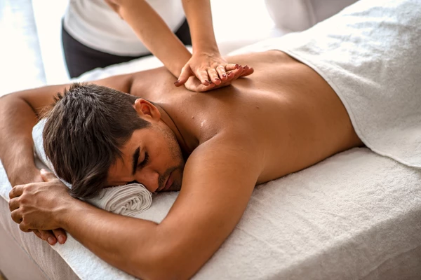 Homme allong&eacute; sur une table de massage pendant un soin du dos